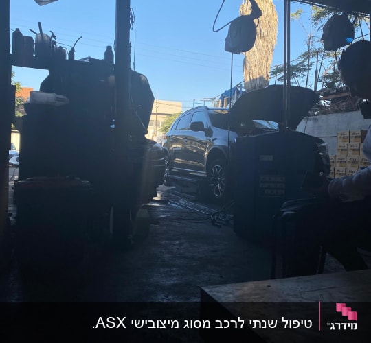 רכב עם מכסה מנוע פתוח במוסך